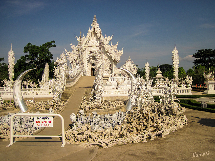 Wat Rong Khun - Weisser Tempel
Die Brücke symbolisiert den Übergang vom Zyklus der Wiedergeburt zum Raum Buddhas. Der kleine Halbkreis davor steht für die Welt des Menschen. Der große Kreis mit Fangzähnen steht für den Mund des Mara (Buddhismus), die Herausforderungen des Lebens auf der Erde.
Wegen der Erdbebenschäden zur Zeit  nicht begehbar.
laut Wikipedia
Schlüsselwörter: Thailand Wat Rong Khun Weisser Tempel