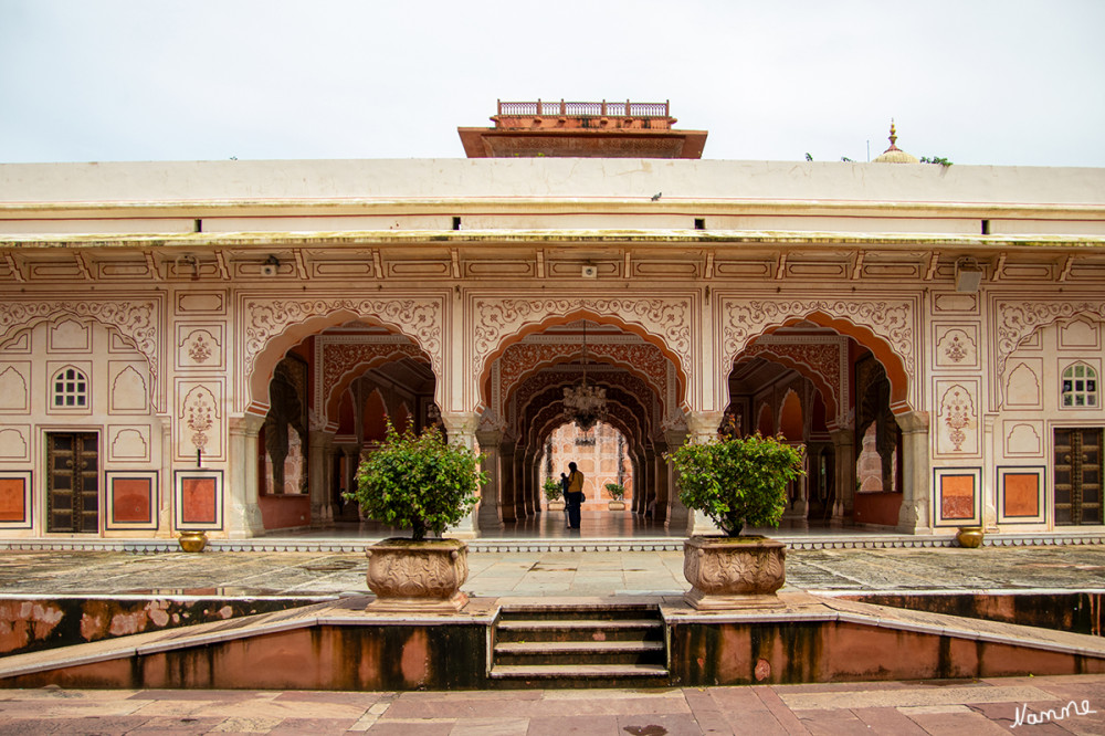 Jaipur Stadtpalast
Nach dem Vorbild einer Mogul-Audienzhalle ist der Diwan-e-Aam, der Sabha Niwas, ein Publikumssaal. Es hat mehrere Spitzbögen, die von Marmorsäulen getragen werden, und eine wunderschön bemalte Gipsdecke. Die Jalis am südlichen Ende der Halle wurden von Frauen genutzt, um die Vorgänge in der Halle zu überwachen und ihre Beteiligung an der Außenwelt zu erleichtern, während sie der Purdah folgten. lt. Wikipedia
Schlüsselwörter: 2024