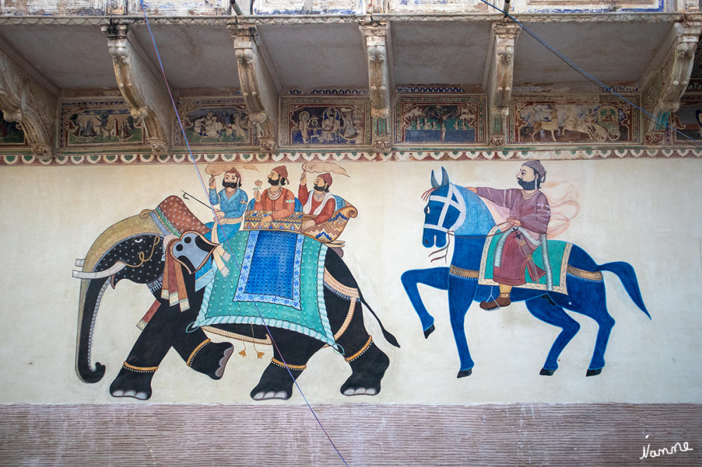 Mandawa Haveli
Die meisten Malereien stammen aus der Zeit um 1900 und zeigen religiöse Motive (Krishna, Radha und die Gopis oder Shiva mit seinem Nandi-Bullen) oder Errungenschaften fremder Länder (Schiffe, Züge, Autos, Fahrräder etc.). lt. Wikipedia 
Schlüsselwörter: 2024