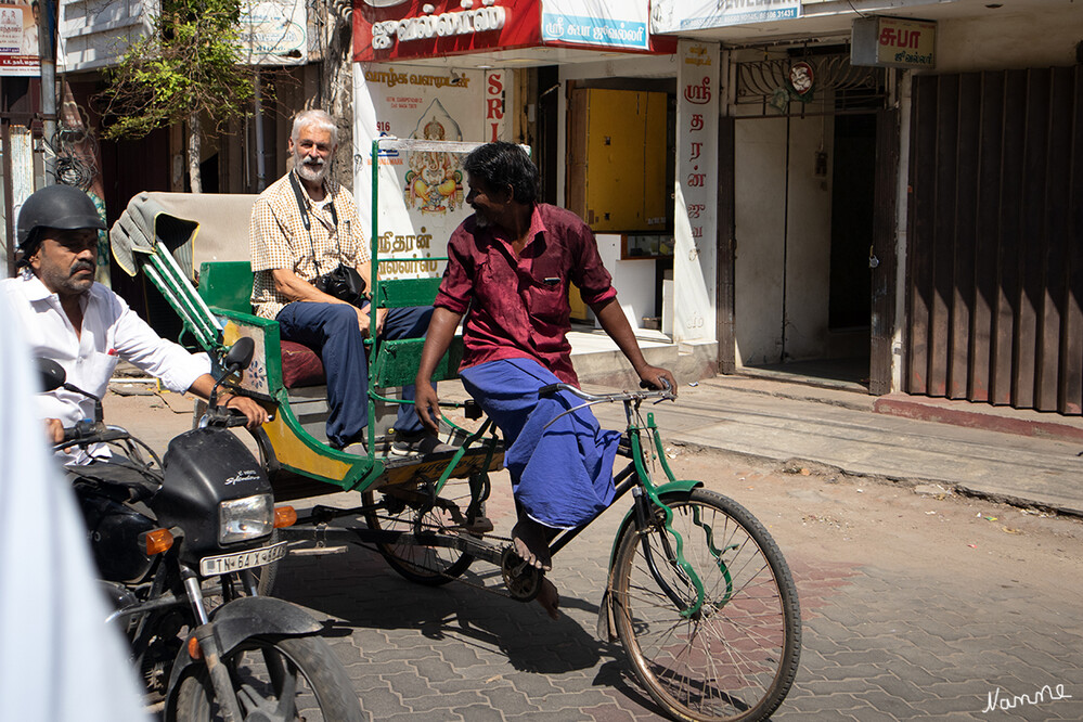 In den Gassen von Madurai
Wir fuhren mit Fahrradrikschas durch die engen Gassen der Altstadt bis zum Meenakshi-Tempel im Herzen der Altstadt. Die Türme sind übersät mit bunten Skulpturen von Göttern, Tieren und mystischen Wesen. Der Minakshi-Tempel ist einer der meistbesuchten Tempel Tamil Nadus. Leider gibt es starke Sicherheitsmassnahmen, ähnlich wie auf einem Flughafen, und fotografieren ist untersagt.
Schlüsselwörter: 2024