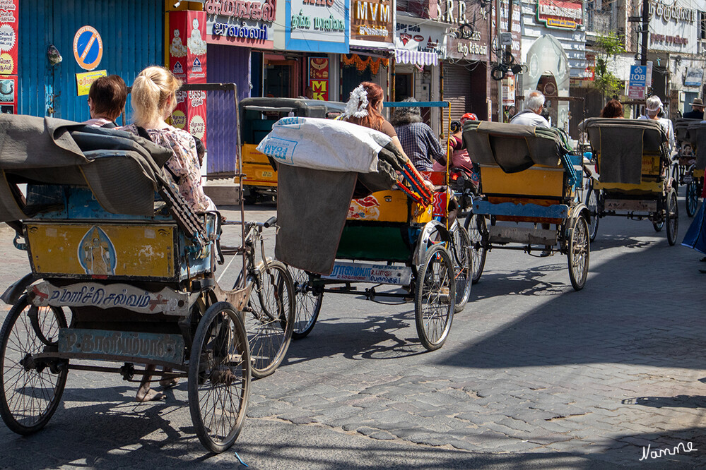 In den Gassen von Madurai
Wir fuhren mit Fahrradrikschas durch die engen Gassen der Altstadt bis zum Meenakshi-Tempel im Herzen der Altstadt. Die Türme sind übersät mit bunten Skulpturen von Göttern, Tieren und mystischen Wesen. Der Minakshi-Tempel ist einer der meistbesuchten Tempel Tamil Nadus. Leider gibt es starke Sicherheitsmassnahmen, ähnlich wie auf einem Flughafen, und fotografieren ist untersagt.
Schlüsselwörter: 2024